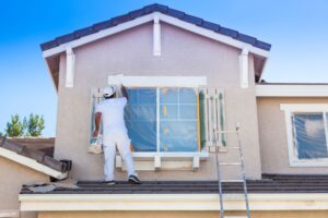 Man painting the exterior of a house