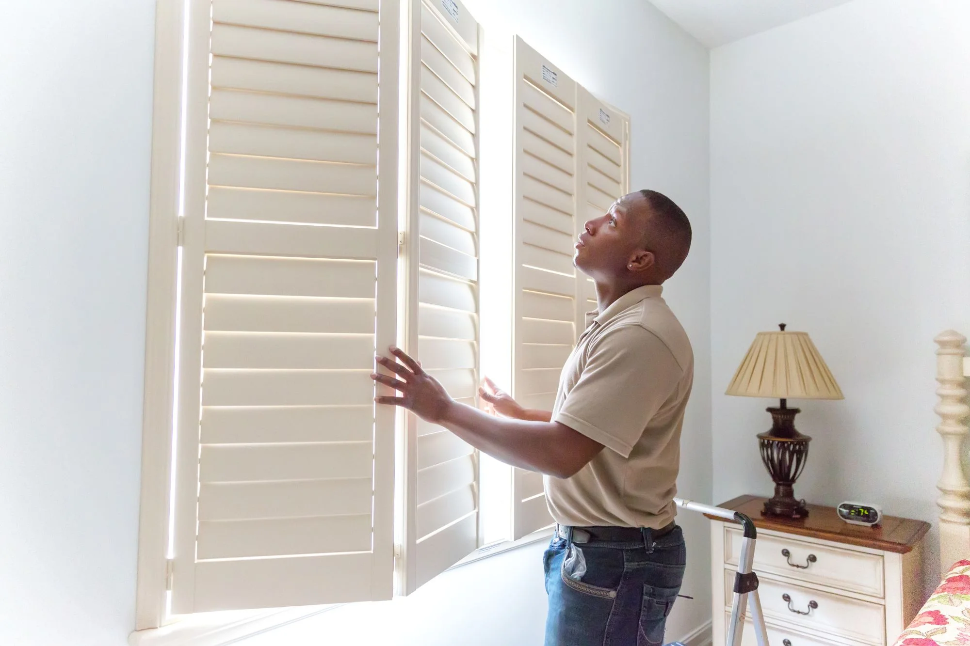 Man installing plantation shutters on a window