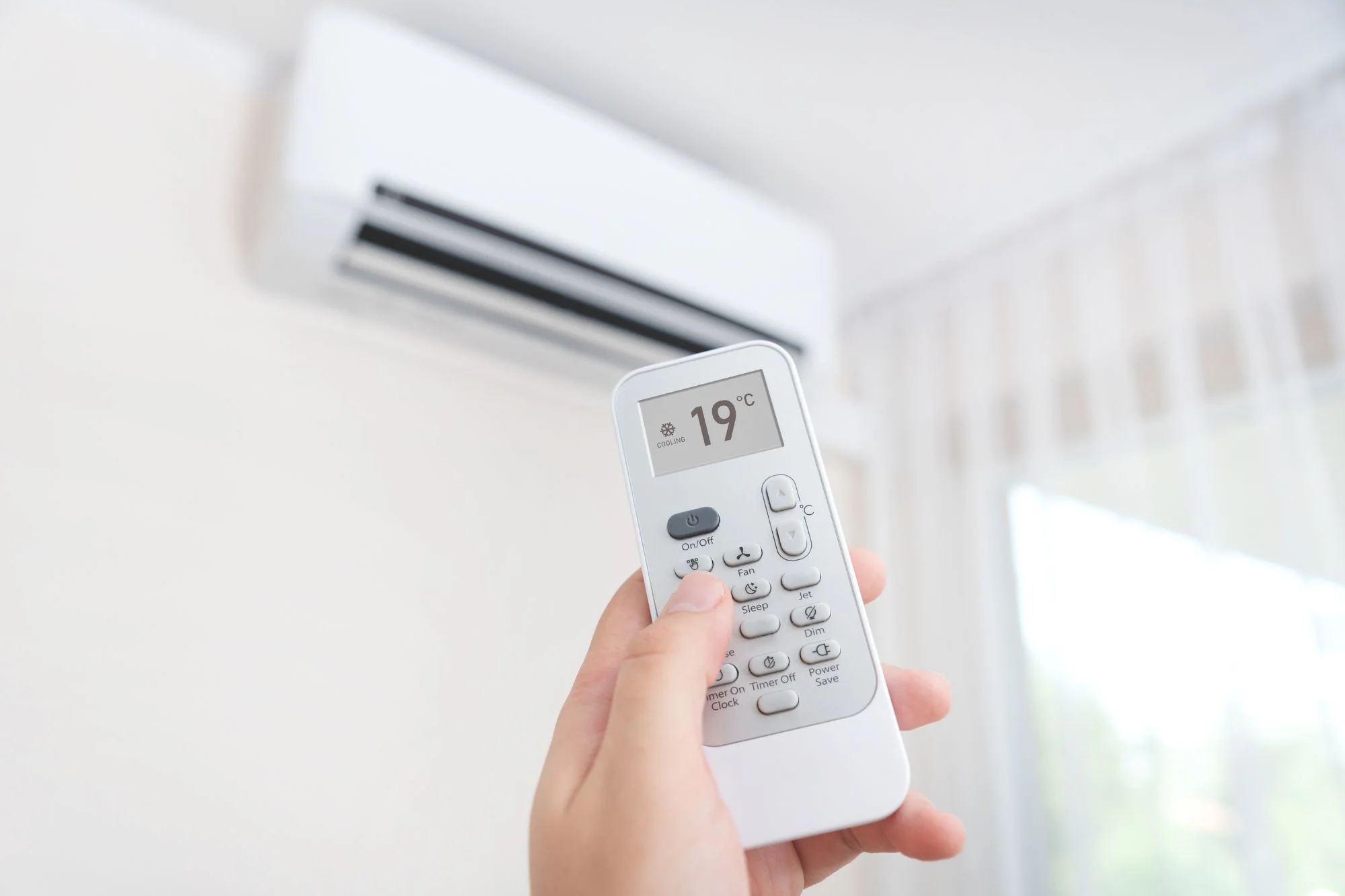 Person turning the air conditioning on with the remote